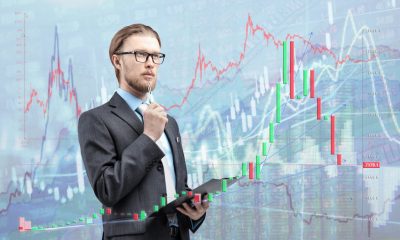 businessman trader analyst in glasses spectacles with notebook and thinking, on diagram background. Trading on stock exchange concept